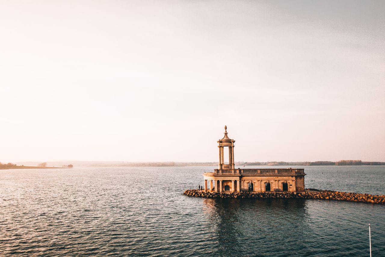 A captivating view of a historic building surrounded by water during sunset near Leicester, UK.